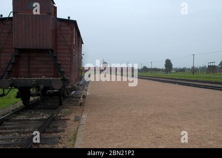 Musée Mémorial de l'Holocauste d'Auschwitz - vue sur la ligne de chemin de fer avec une voiture jusqu'au portier d'Auschwitz II-Birkenau au loin Banque D'Images