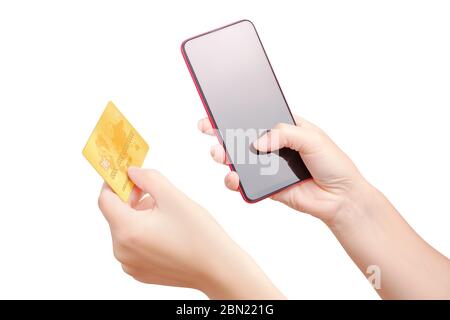 Gros plan des mains des femmes avec smartphone et carte de crédit dorée isolée sur fond blanc avec masque. Fille entre des données pour le shopping en ligne. Banque D'Images