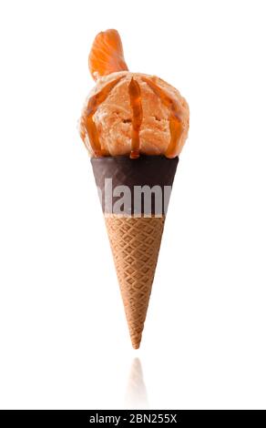 Crème glacée à la crème parfumée à la mandarine avec des morceaux de fruits isolés sur fond blanc sur cône de chocolat semi-trempé Banque D'Images