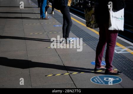 Les passagers se tiennent à l'écart sur une plate-forme à la station de métro Canning Town de Londres. Banque D'Images