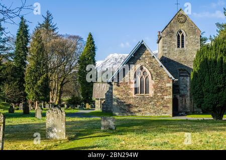 Église Saint-Patrick de Patterdale avec le district des lacs enneigés grelots en arrière-plan Banque D'Images