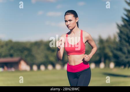 Bonne humeur ensoleillée. Jeune athlète de course à l'extérieur, entraînement pour la course de marathon. Magnifique modèle de fitness, avec des tenues de sport très agréables Banque D'Images