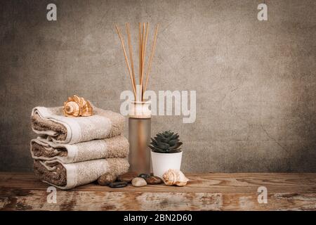 Produits de spa, bâtonnets d'arôme, pierres, serviettes, coquillages sur un fond rustique en bois Banque D'Images