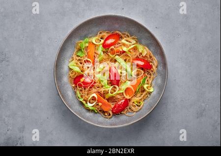 Veg Pad Woon Sen ou Thai Glass Noodle Stir-Fry ou Pad Thai dans un bol sur fond de béton gris. Le végétarien Pad Woon Sen est un plat thaïlandais de noo de haricots en verre Banque D'Images