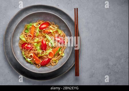 Veg Pad Woon Sen ou Thai Glass Noodle Stir-Fry ou Pad Thai dans un bol sur fond de béton gris. Le végétarien Pad Woon Sen est un plat thaïlandais de noo de haricots en verre Banque D'Images