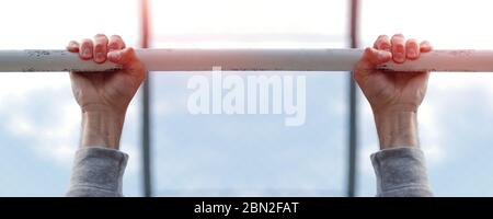 mains d'un homme fort tenant sur l'arrière-plan sportif de l'arceau Banque D'Images