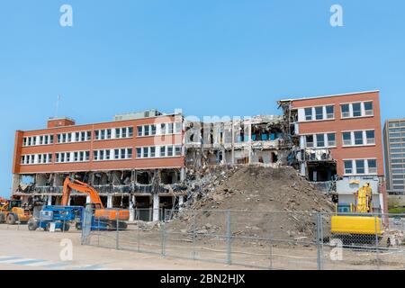 Un bâtiment partiellement démoli. Une grande partie du centre du bâtiment est manquante, et il y a une grosse pile de terre devant. Beaucoup de débris et de pendaison Banque D'Images