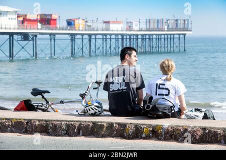 Une pause en couple après le vélo sur le front de mer à Paignton, Royaume-Uni Banque D'Images