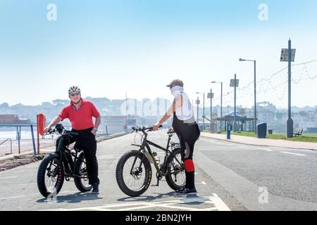 Des hommes en VTT près de la jetée fermée sur la plage de Paignton pendant le confinement du coronavirus, au Royaume-Uni Banque D'Images