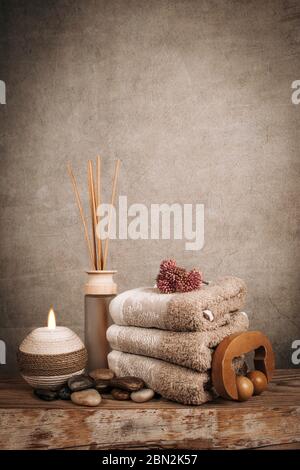 Produits de spa, bâtonnets d'arôme, pierres, serviettes, coquillages sur un fond rustique en bois Banque D'Images