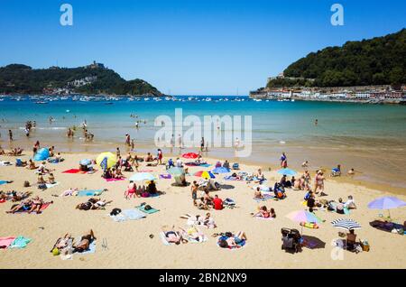 San Sebastian, Gipuzkoa, pays Basque, Espagne : bains de soleil à la plage de la Concha dans la baie de la Concha. Banque D'Images
