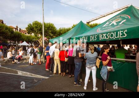Saint Jean de Luz, pays basque français, France - 13 juillet 2019 : les gens se tiennent à côté d'un comptoir à bière sur la place Louis XIV pendant le 14 juillet, le 14 juillet Banque D'Images