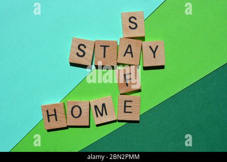 Stay, Safe, Home, Words in 3d Wood alphabet lettres en forme de mots croisés sur vert Banque D'Images