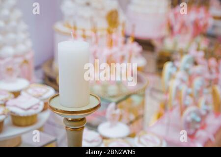 Festival, dîner, vacances, nouvel an . Bar Candy rose . Porte-bougie en laiton . Bougie isolée sur l'arrière-plan flou. Bougie pour dîner de nuit, Banque D'Images