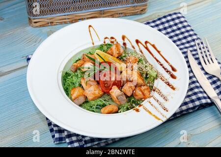 Nouilles de riz au saumon et aux épinards. Déjeuner dans une assiette blanche sur la table. Tomates, citron, poisson, romarin, soi et graines de sésame. La nourriture reste vie Banque D'Images