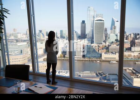 Femme d'affaires attentionnés qui regarde la vue sur le paysage urbain, Londres, Royaume-Uni Banque D'Images