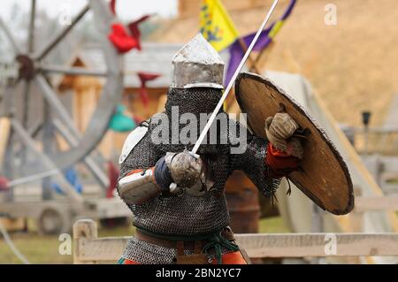 Reenactor vêtu d'une armure de combat médiéval de chevalier reconstruit des épées Banque D'Images