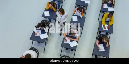 Vue depuis le haut enseignant du secondaire supervisant les élèves qui prennent l'examen Banque D'Images