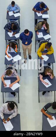 Vue depuis le haut enseignant du secondaire supervisant les élèves qui prennent l'examen Banque D'Images