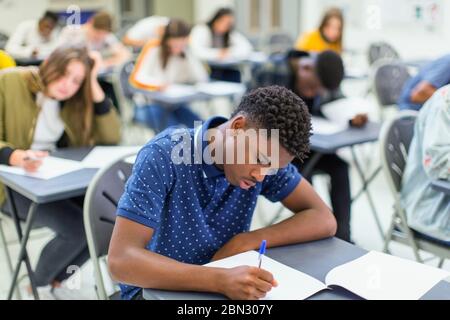 Élève d'un lycée ciblé qui se présente à l'examen à la table en classe Banque D'Images