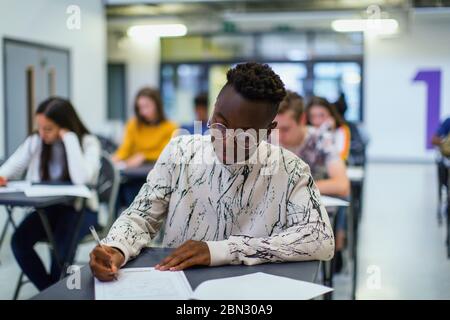 Élève d'un lycée ciblé qui se présente à l'examen à la table en classe Banque D'Images