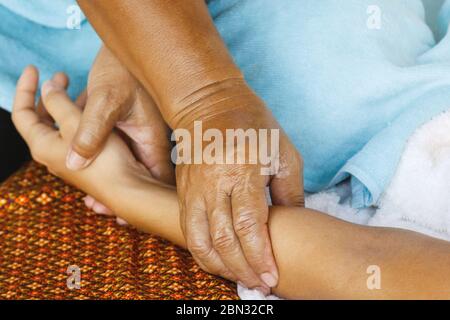 Main féminine pendant le massage thaïlandais traditionnel Banque D'Images