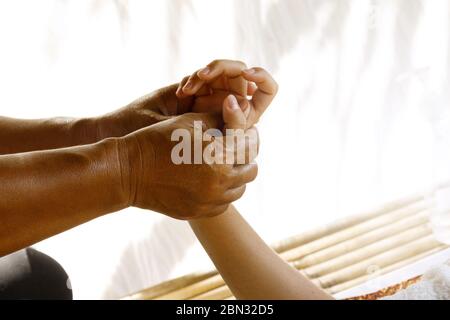 Main féminine pendant le massage thaïlandais traditionnel Banque D'Images