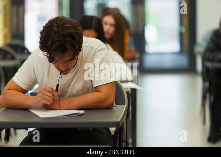 Élève d'un lycée ciblé qui se présente à l'examen à la table en classe Banque D'Images