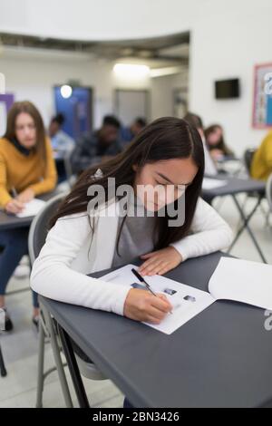 Une fille du lycée qui se présente à l'examen à son bureau en classe Banque D'Images