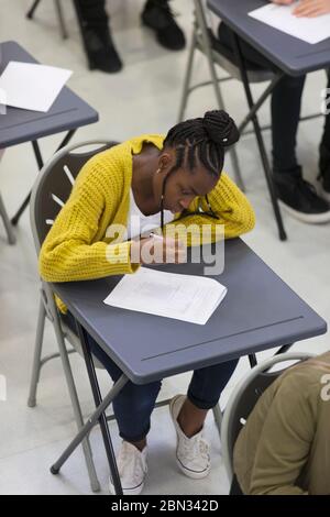 Jeune fille d'école secondaire ciblée prenant l'examen à bureau en classe Banque D'Images