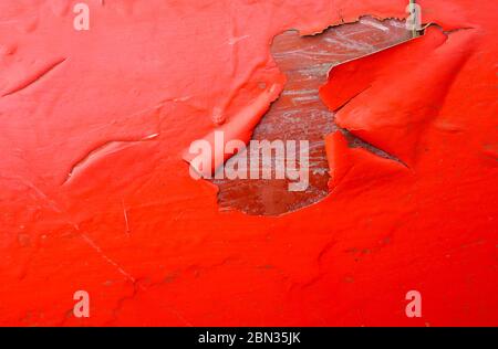 Peinture rouge écaillée sur le fond en fibre de verre du canot Banque D'Images