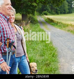 Deux aînés heureux avec randonnée de chien dans la forêt Banque D'Images