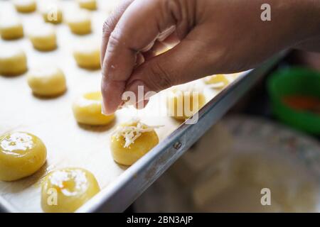 versez un peu de fromage à la main sur le gâteau nastar à l'ananas pour le nappage Banque D'Images