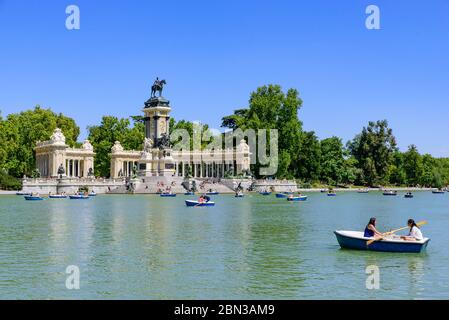 Les gens ravirent des bateaux sur le lac du parc Retiro à Madrid, Espagne Banque D'Images