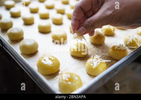 versez un peu de fromage à la main sur le gâteau nastar à l'ananas pour le nappage Banque D'Images