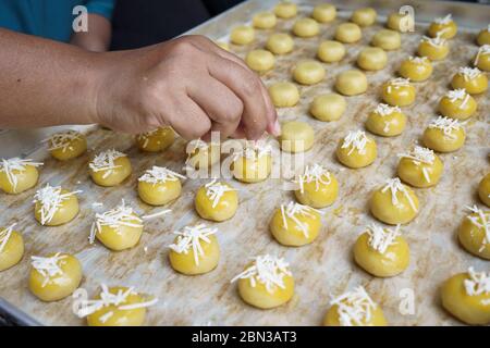 versez un peu de fromage à la main sur le gâteau nastar à l'ananas pour le nappage Banque D'Images