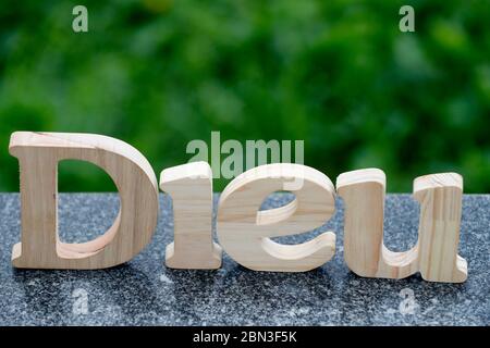 Lettres en bois formant le mot Dieu ( dieu ) sur fond de marbre noir. Symbole chrétien. Banque D'Images