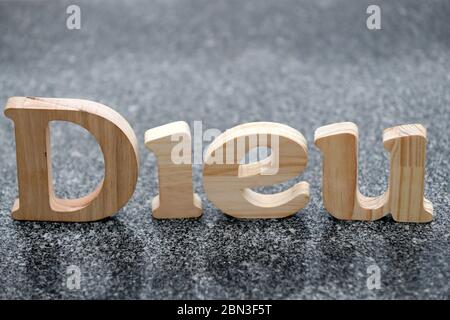 Lettres en bois formant le mot Dieu ( dieu ) sur fond de marbre noir. Symbole chrétien. Banque D'Images