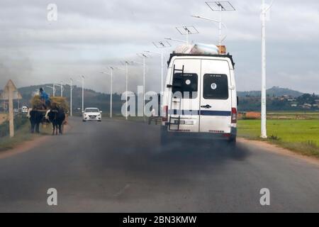 Vieux minibus émettant de la fumée noire sur la route. Pollution. Antananarivo. Madagascar. Banque D'Images