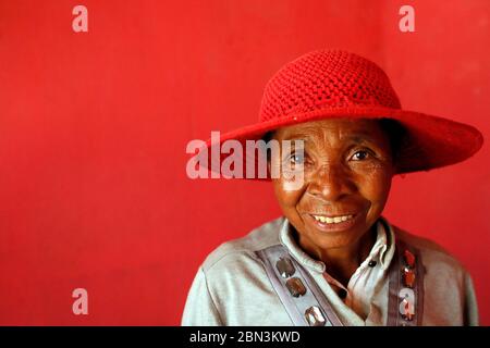 Femme malgache frayeuse avec un chapeau rouge. Portrait. Madagascar. Banque D'Images