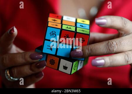 Femme africaine avec un cube de Rubik avec des symboles religieux. Concept de dialogue interreligieux et interreligieux. Madagascar. Banque D'Images