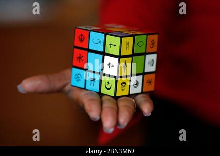 Femme africaine avec un cube de Rubik avec des symboles religieux. Concept de dialogue interreligieux et interreligieux. Madagascar. Banque D'Images