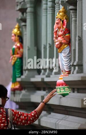 Temple hindou Sri Mahamariamman. Femme priant à la statue de la déité hindoue de Ganesh. Kuala Lumpur. Malaisie. Banque D'Images