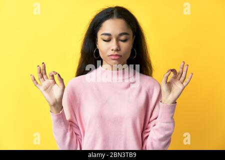 Décontractée jolie femme garde les mains dans le geste mudra avec les yeux fermés. Méditation, concept de patience Banque D'Images