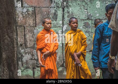 Jeunes Monks bouddhistes marchant dans le Temple dans des robes de Saffron et regardant sur Angkor Wat. Temple Banteay Kdei. Siem Reap, Cambodge - 25 FÉVRIER 2020 Banque D'Images