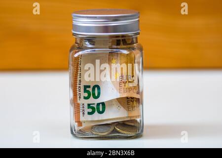 Composition avec billets d'argent économisant dans un pot en verre. Concept d'investissement et de maintien de l'argent, isolé. Banque D'Images