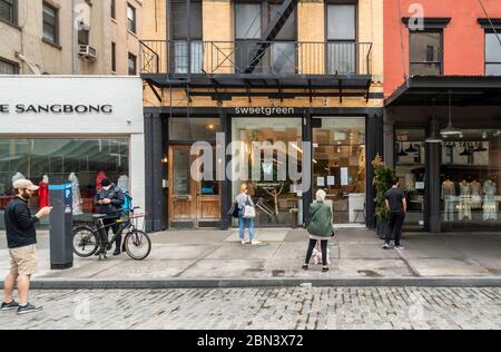 Les clients observent les protocoles de distance sociale en attendant leurs commandes devant un restaurant Sweetgreen à New York le vendredi 1er mai 2020 . (© Richard B. Levine) Banque D'Images