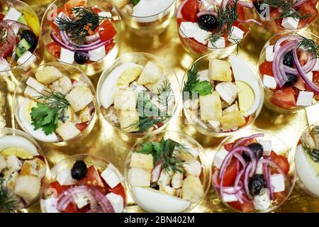 Deux types de salade disposés en verres sur une table dorée Banque D'Images