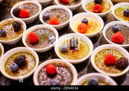 Deux types de soufflé dans des bols blancs décorés de framboises, de bleuets et de mûres Banque D'Images