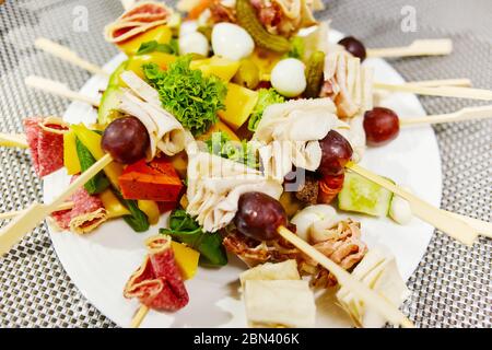 Kebabs de légumes posés sur une plaque blanche photographiés de près Banque D'Images